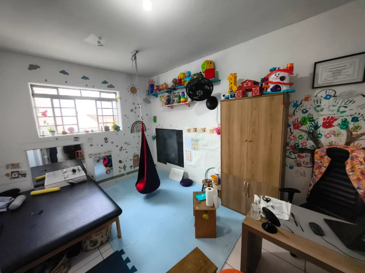 Sala de terapia com balanço sensorial e brinquedos
