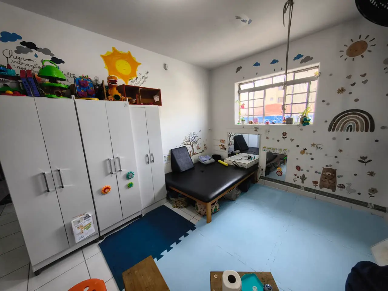 Sala terapêutica com armários e decoração lúdica